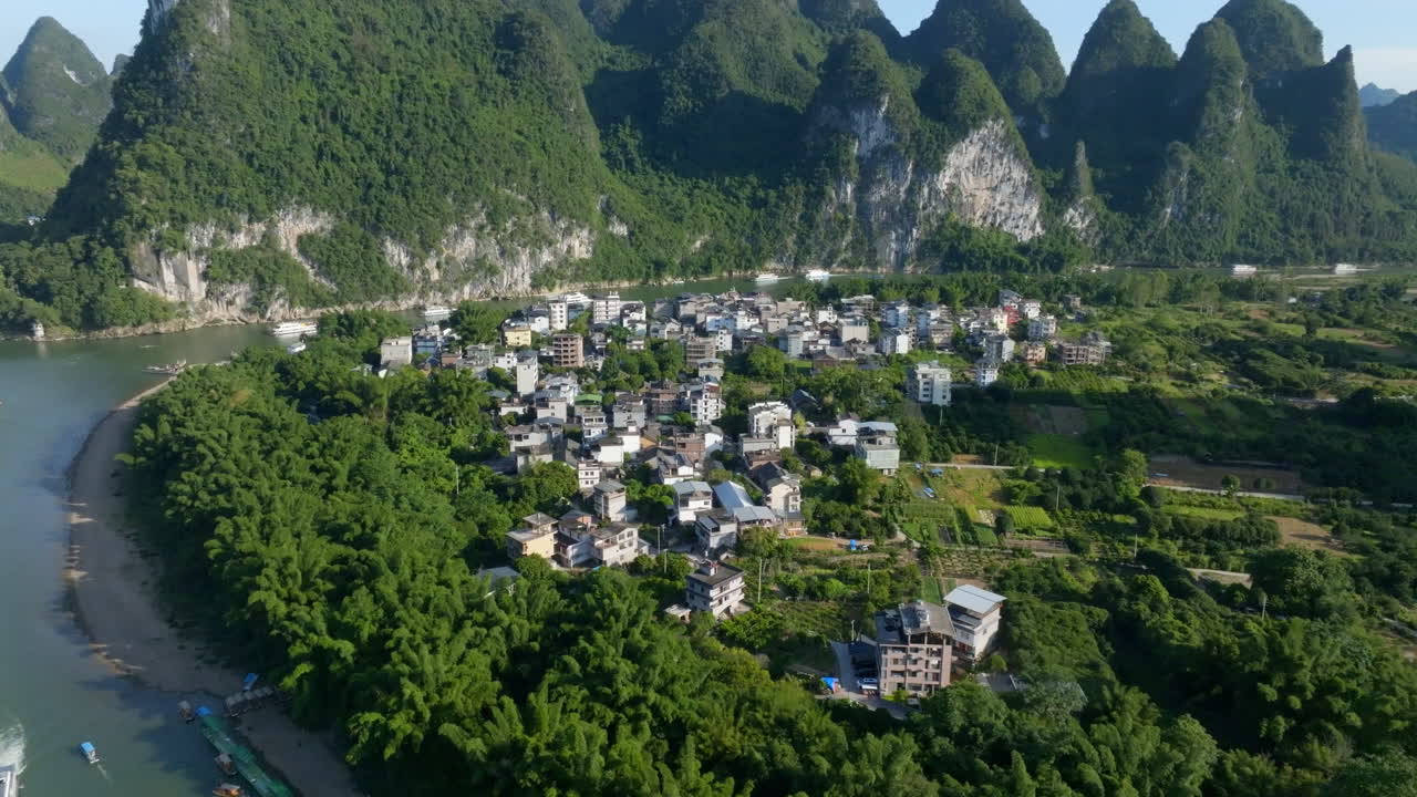 Panoramic drone shot circling houses in Xingping Ancient Town, China, summer day