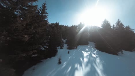 flying fpv up the side of a snowy mountain dodging between the trees