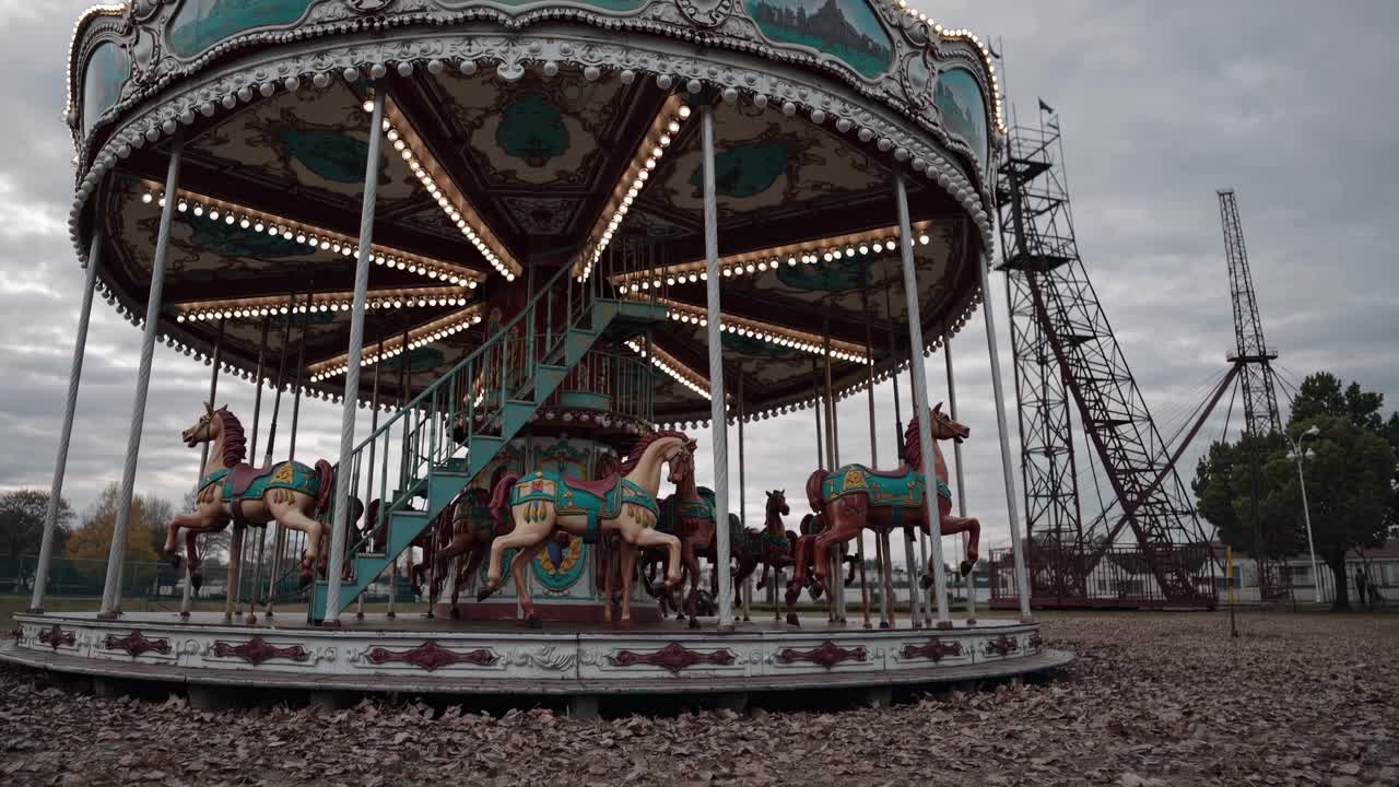 A vintage carousel in an abandoned park, captured from a low-angle, creates a nostalgic and eerie