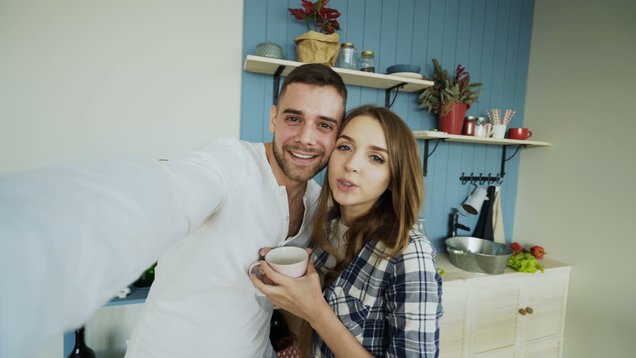 Coppia felice che si scatta un selfie in cucina
