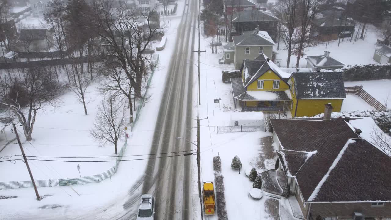 Canadian city winter storm, snow-covered streets, low traffic volume, observed from a drone