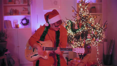 hombre alegre tocando la guitarra en casa durante la navidad