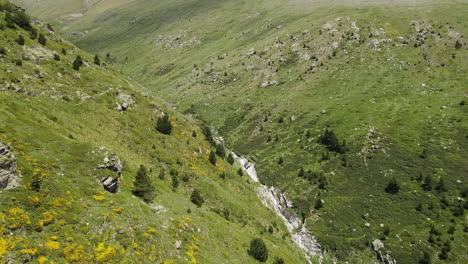 veduta aerea di un drone che segue un sentiero situato tra le pendici di due montagne pirenaiche