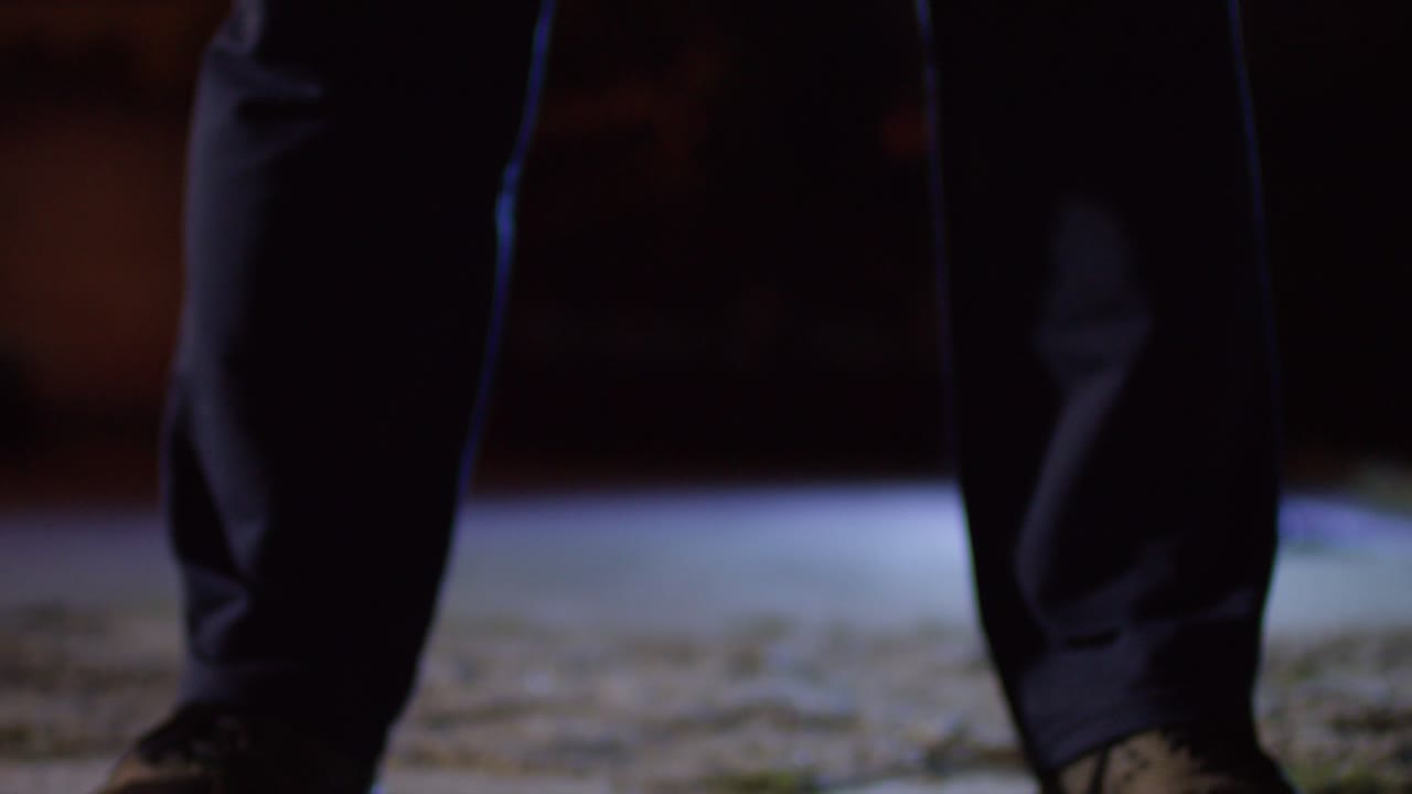 persona levantando una barra en una habitación oscura