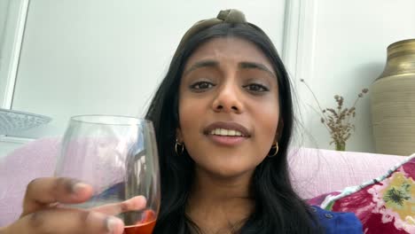 woman saying cheers to the camera on video chat