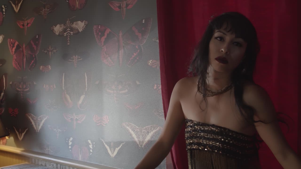 赤いカーテンの近くと壁紙で捕らえられた美しい女性