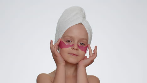 smiling child girl applying pink patches under eyes, teenager natural skin care, perfect fresh clean