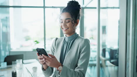 businesswoman smiling while using her phone in the office