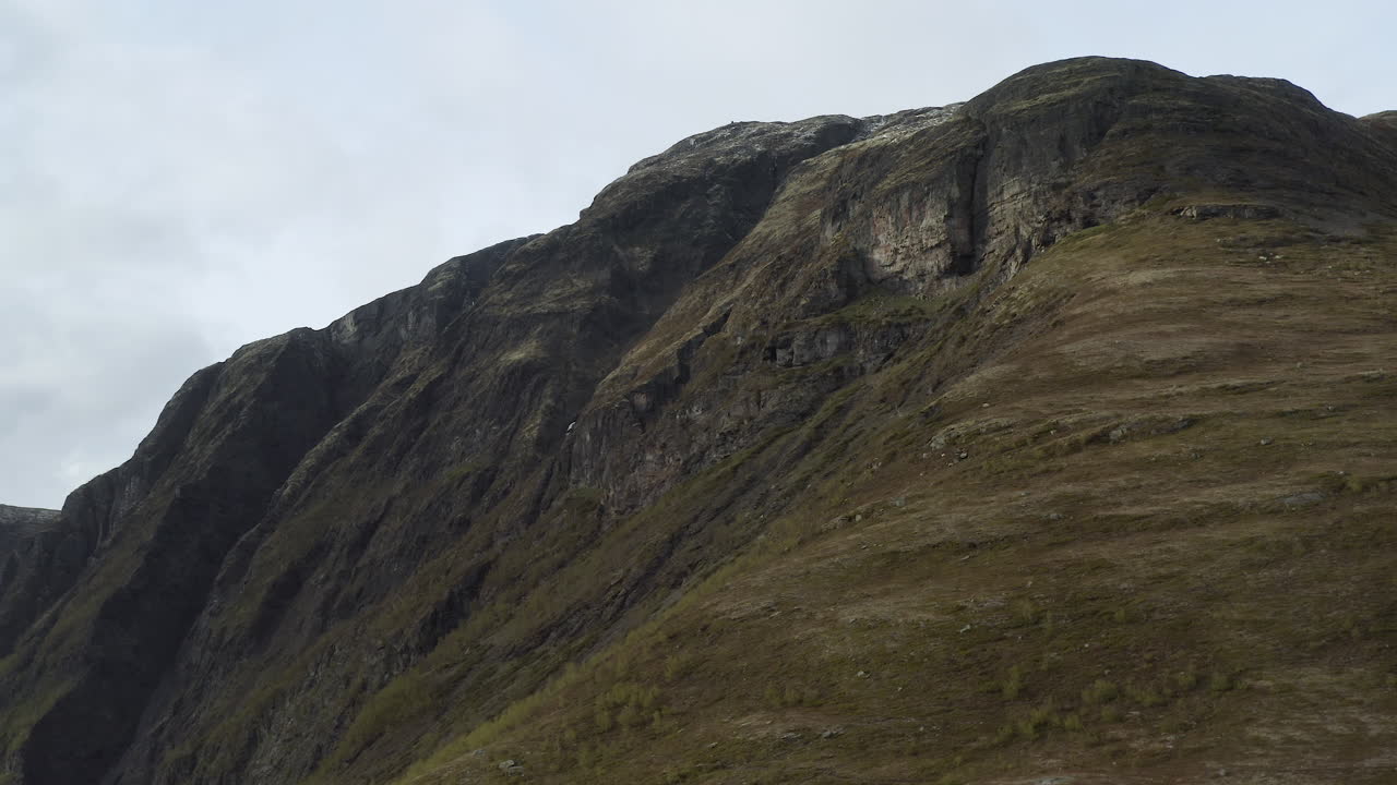 Areal footage over Aurland and Aurlandsfjord in Norway. Moody day with clouds, and the sun shining through.