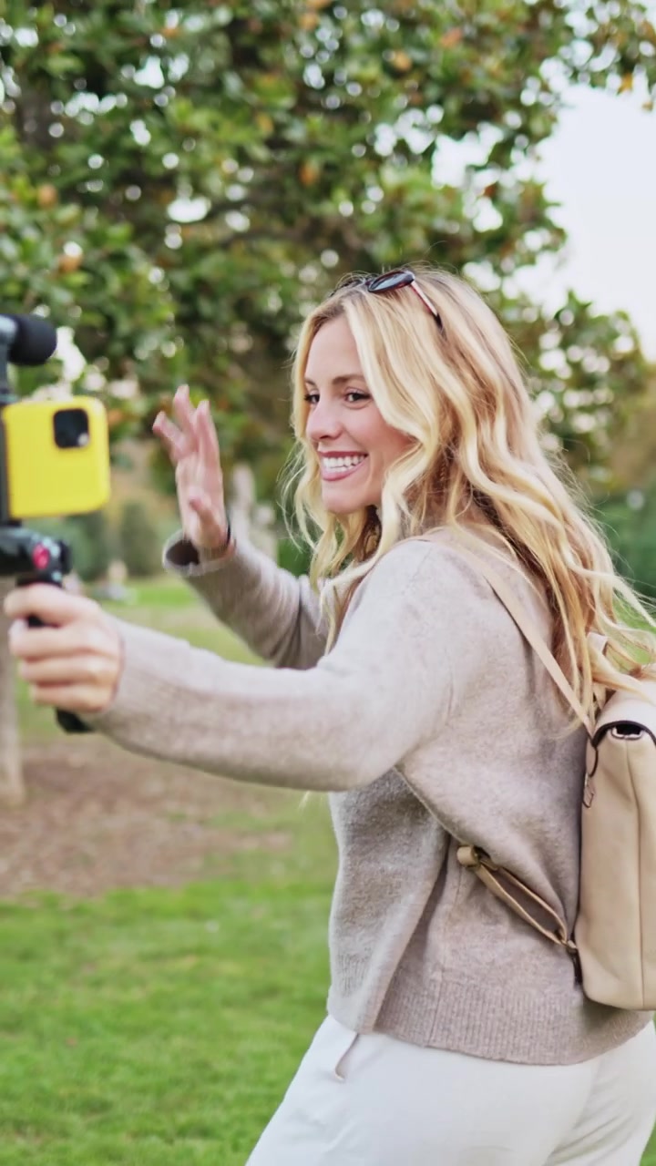 Donna allegra che registra un video con lo smartphone nel parco