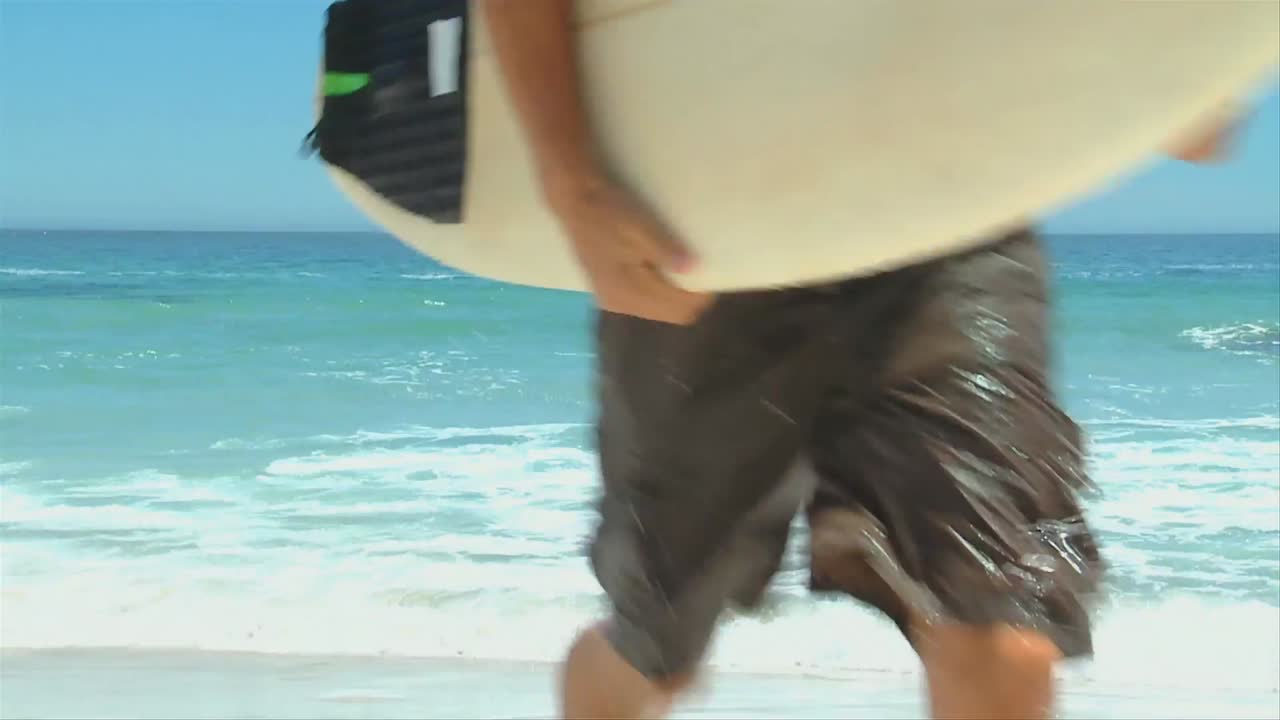 hombre saliendo del mar con su tabla de surf