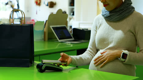 pregnant woman paying bill at counter 4k