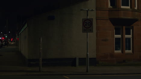 faulty flashing 20 mph sign in empty street at night