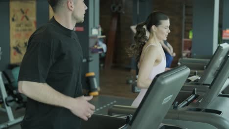 man and woman working out on treadmills in a gym