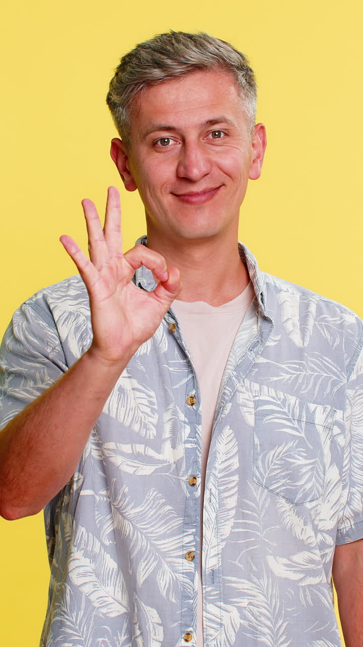 Adult man showing ok hand gesture with confident positive expression expressing support and approval