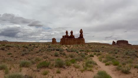 Walking-towards-the-Three-Sisters-geological-formation-in-Utah's-Goblin-Valley