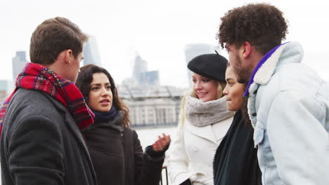 amigos caminando por la orilla sur en una visita de invierno a londres