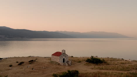 panoramic view of the sveti marin chapel during sunrise, novi vinodolski, croatia, cinematic aerial shot of a church on an island with seagulls flying by, golden hour view of the peaceful adriatic sea