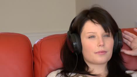mujer atractiva escuchando música sentada en la cama
