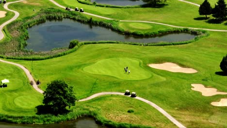 golf players walking on green grass field near lake in newton, surrey, bc, canada