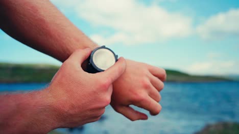 reloj inteligente en la muñeca de un hombre caucásico sobre senderos de senderismo