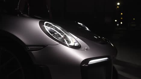 modern new sport car front detail on the reflector and drl led light in the dark in 4k