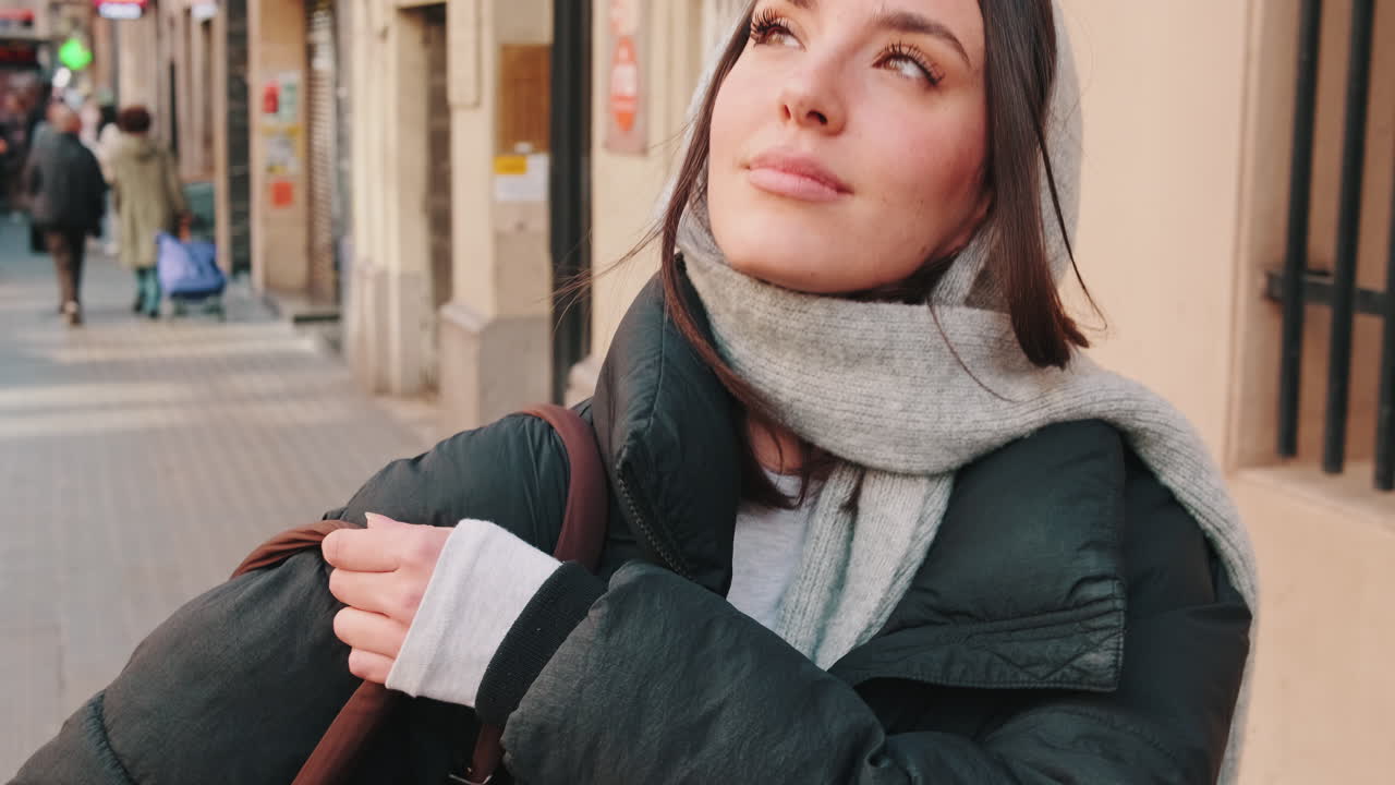 Thoughtful Young Woman Enjoying the Sun on an Urban Sidewalk