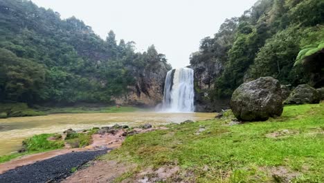 la cascada de hunua fluye hacia un río fangoso en un día de lluvia, toma amplia en cámara lenta