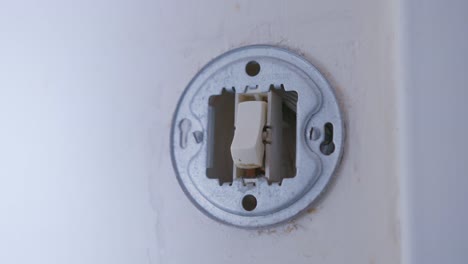 persona apagando el interruptor de la luz antes de salir de la casa
