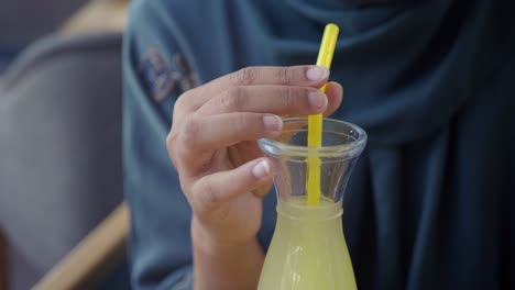 woman in hijab enjoying a refreshing drink