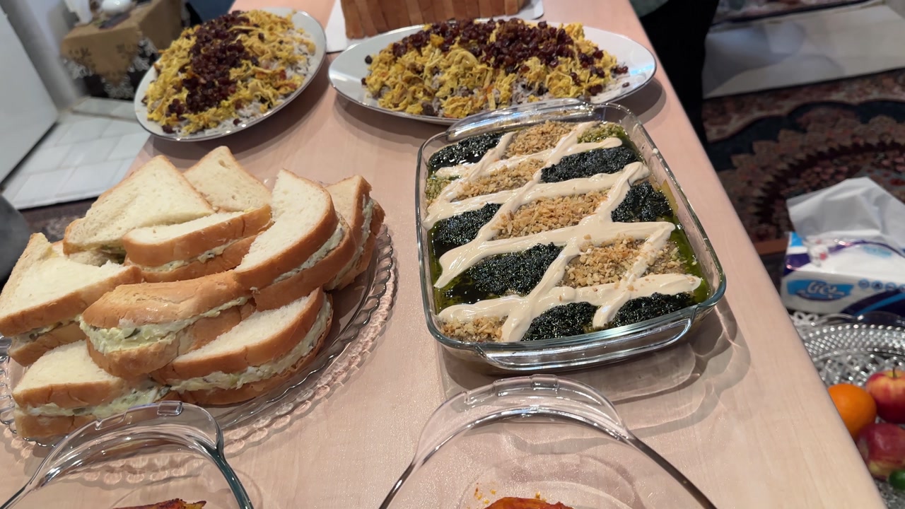 Persian party buffet grilled sausages platter kashke bademjan roasted eggplant handmade dips and healthy vegetable dishes Indoor dining for family and relatives with hot flavorful local people meals