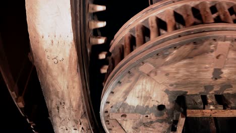4k enormes ruedas dentadas de madera giran juntas en primer plano. mecanismo de molino de viento tradicional en el interior. relojes antiguos girando rápido