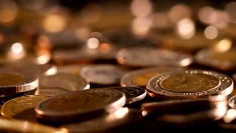 pan shot of close up money coin stacking on  the floor in dark light , business and financial for money saving or the investment background concept  , extremely close up and shallow dof