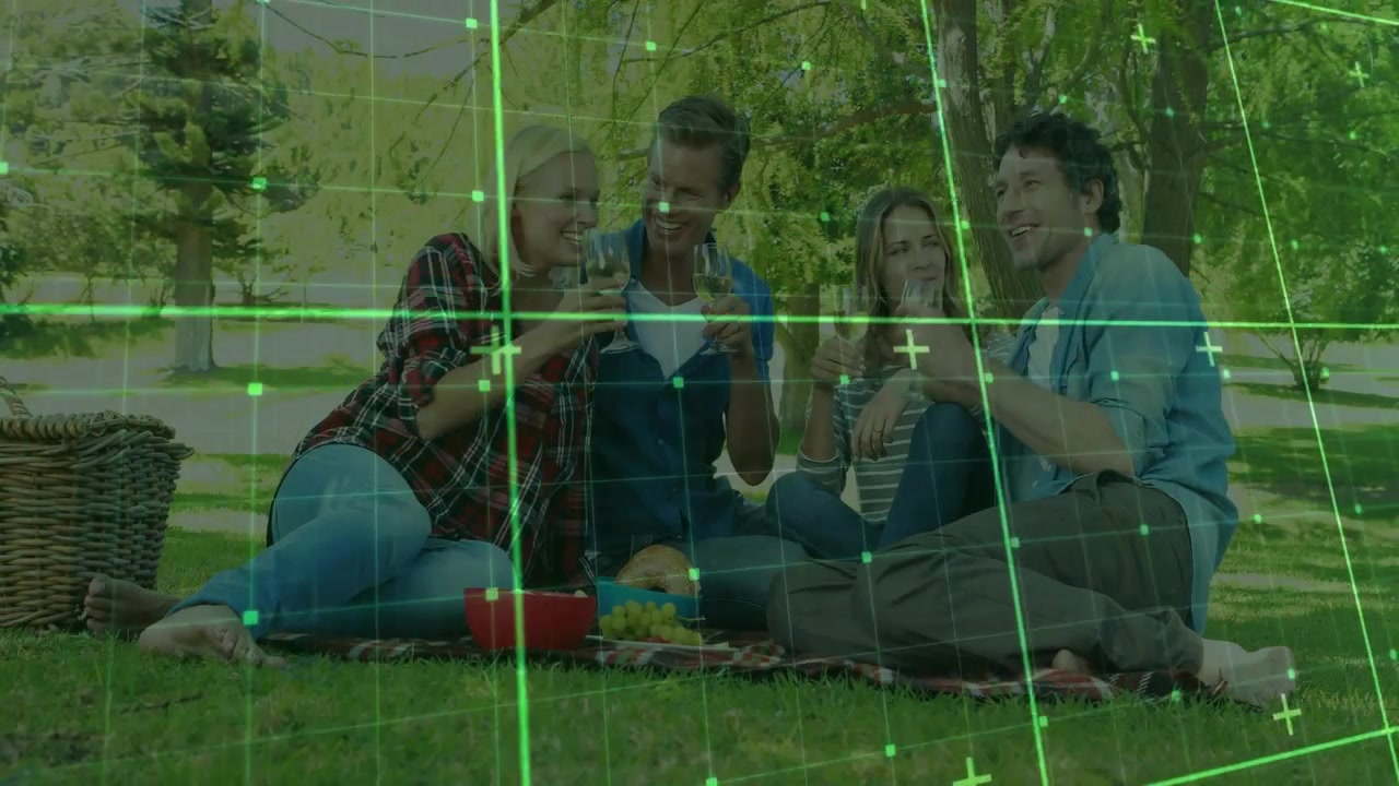 Scena di svago che mostra quattro amici su una coperta tra gli alberi, che prendono una bottiglia e versano vino per brindare