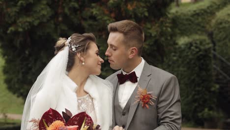 Newlyweds,-caucasian-groom-with-bride-walking,-embracing,-hugs-in-park,-wedding-couple