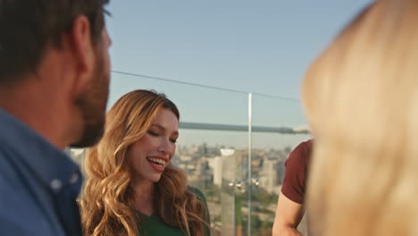 partying friends talking together on sunny rooftop closeup. smiling people enjoy