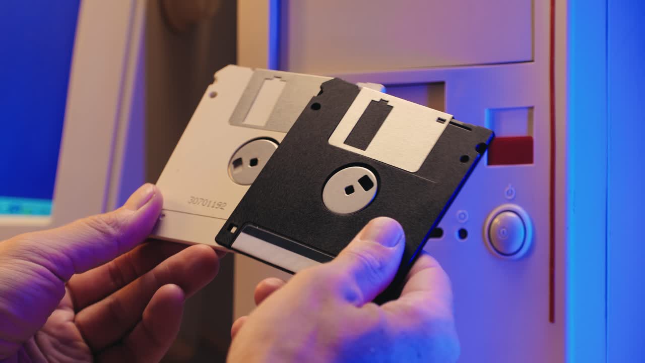 Using diskette for old computer. Music recorder, playing retro computer games. Vintage device for office, obsolete technology. . High quality 4k footage
