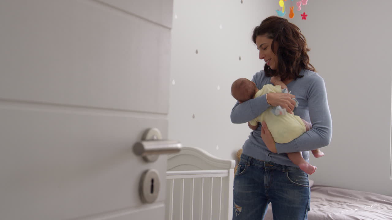 Mère réconfortant son bébé garçon dans la chambre d'enfant