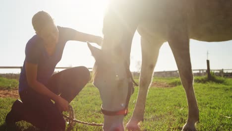 Woman-stroking-horse-while-grazing-in-ranch-4k
