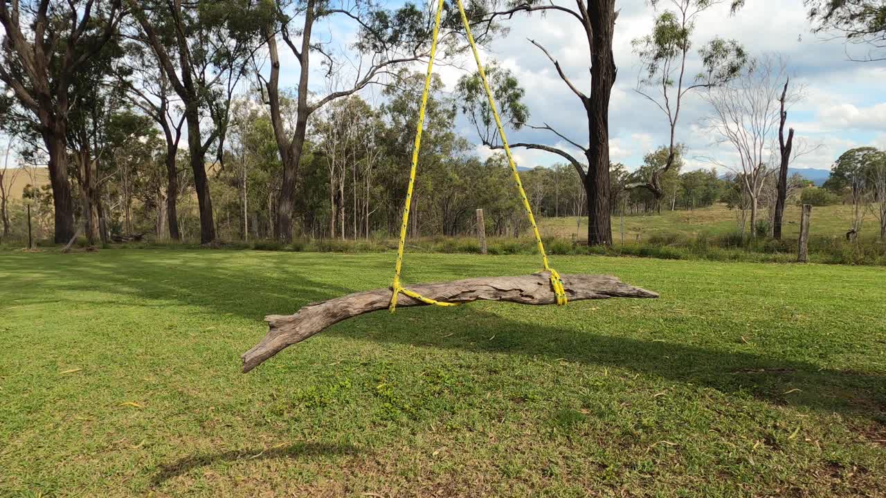 columpio de árbol de palo balanceándose en la brisa en una granja rural