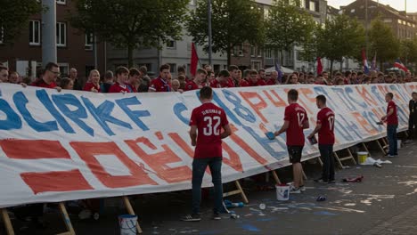 enthusiastic fans collaborate to create a colorful banner at a local event, showcasing team spirit and community passion with vibrant paint and cheers