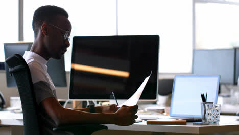 Male-executive-checking-document-at-desk-4k