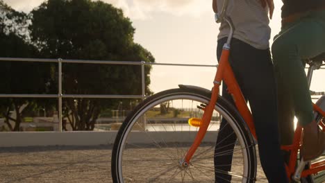 couple interacting with each other in cycle at beach 4k