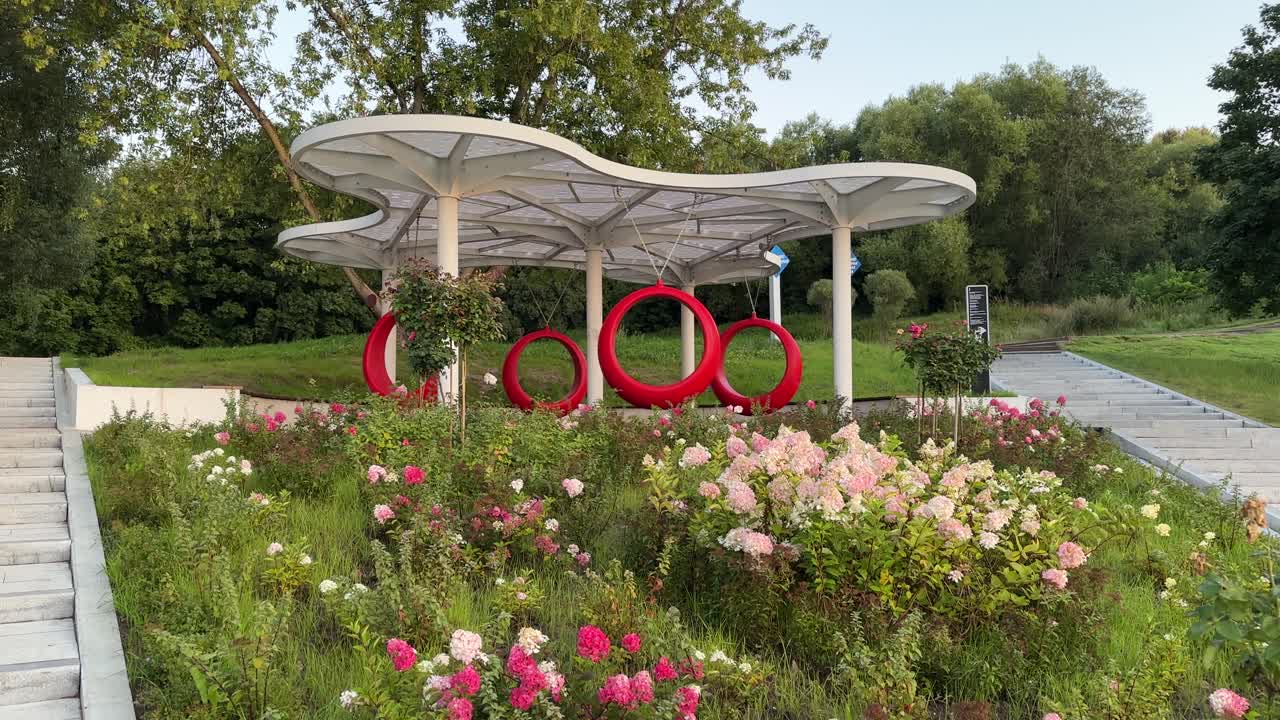 Red round designer swing in the park (4K60)