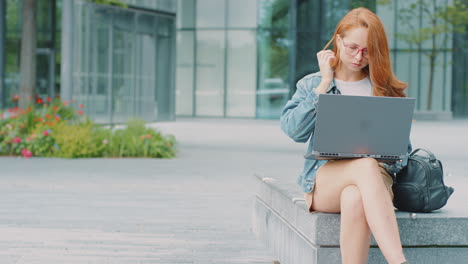 Female-Vlogger-Or-Social-Influencer-Travelling-Through-City-For-Social-Media-Using-Laptop-Outdoors