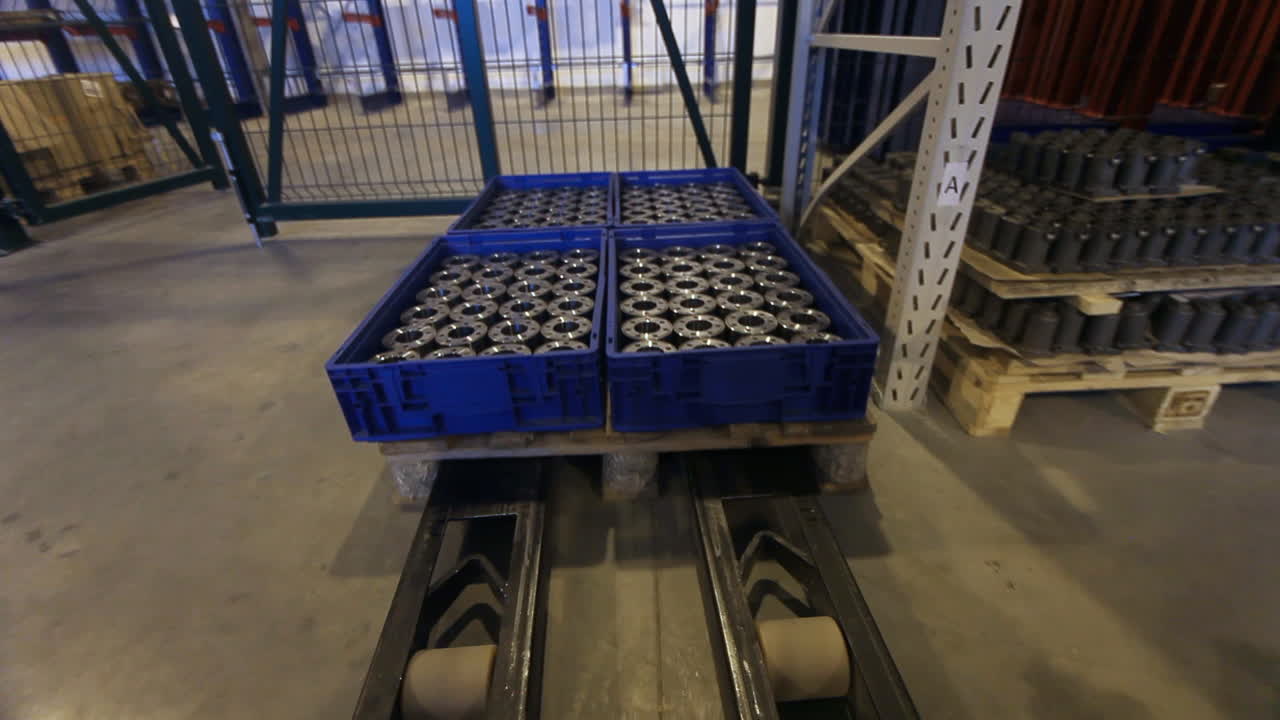 vista superior de un camión de montacargas que va a cargar cajas con paletas metálicas.