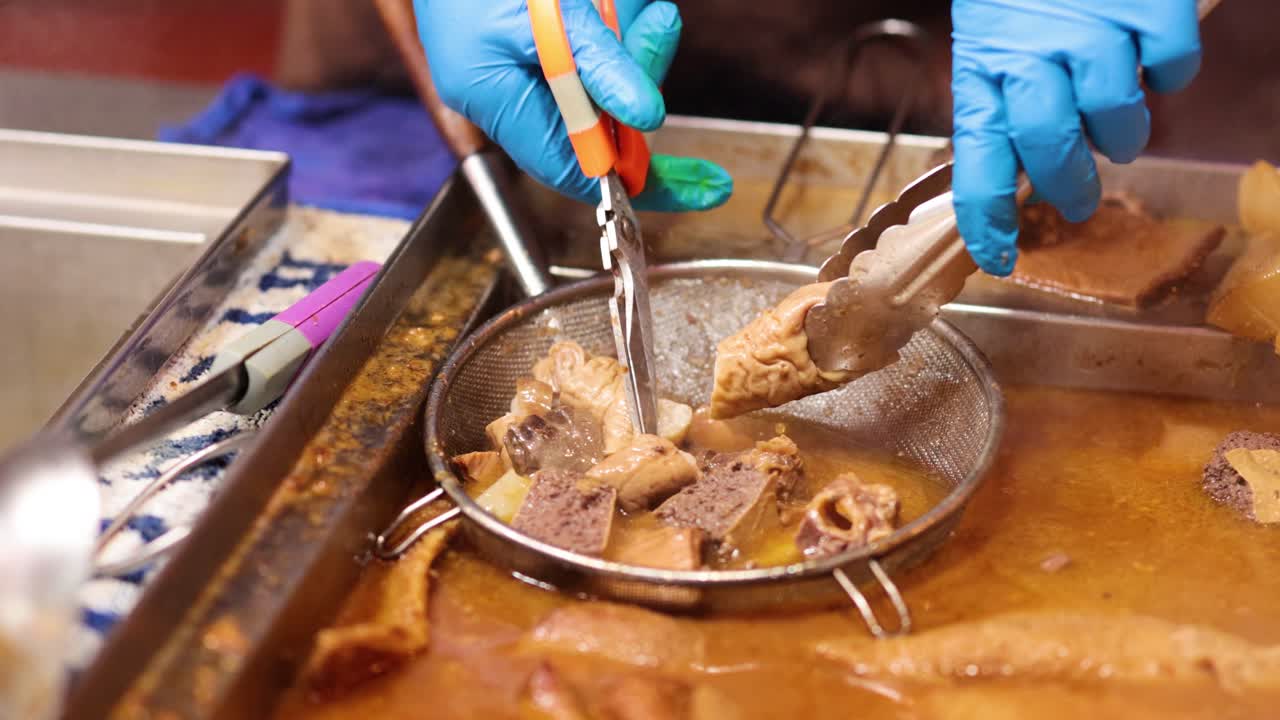 cocinero manejando despojos con pinzas y guantes