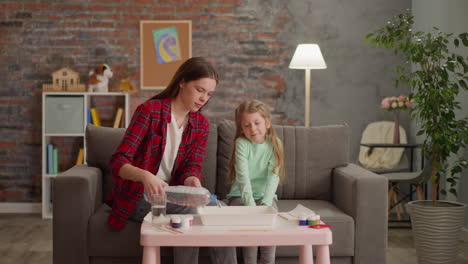 Ältere-Schwester-Gießt-Wasser-Für-Ebru-Zeichnung-Mit-Kleinem-Mädchen