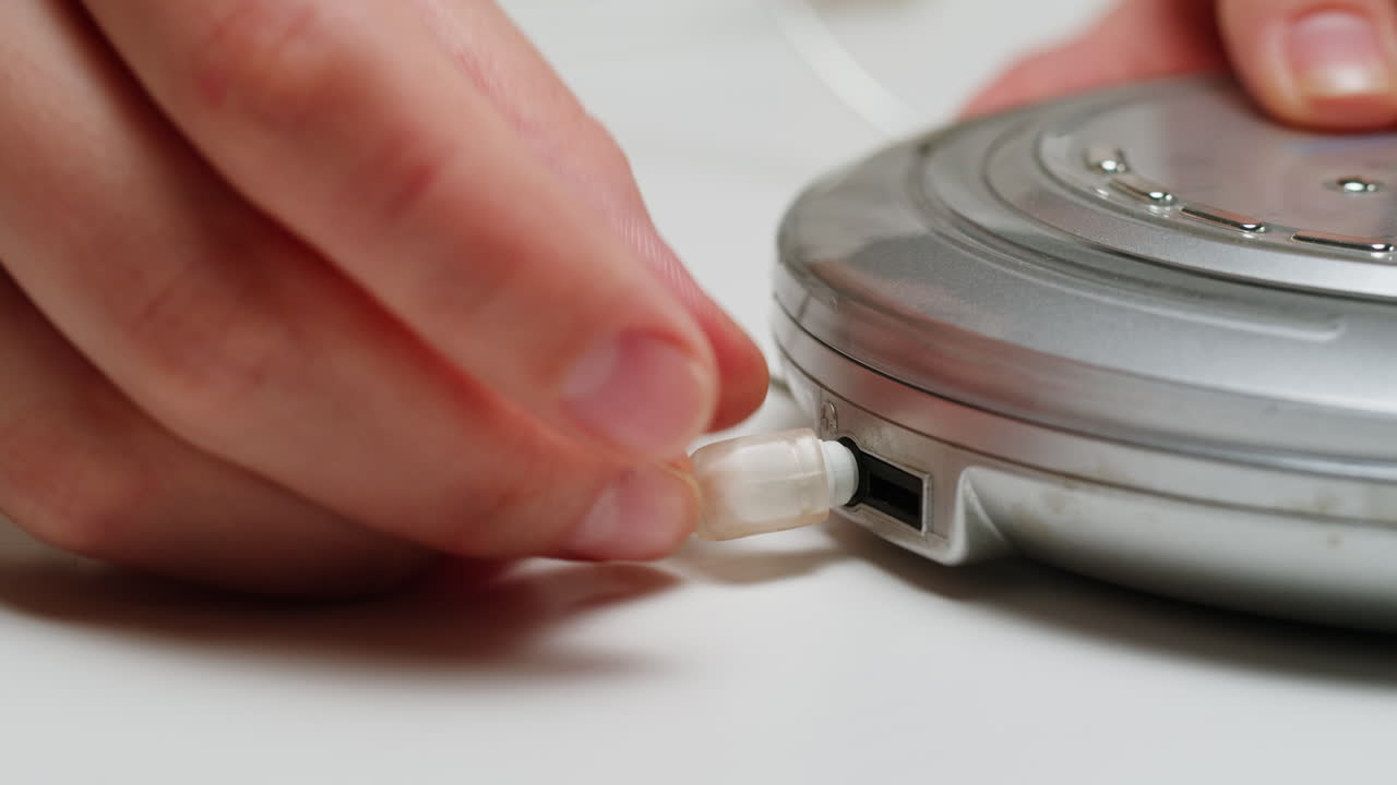 Using headphone for old music portable compact player close-up. Listen to music with vintage player.