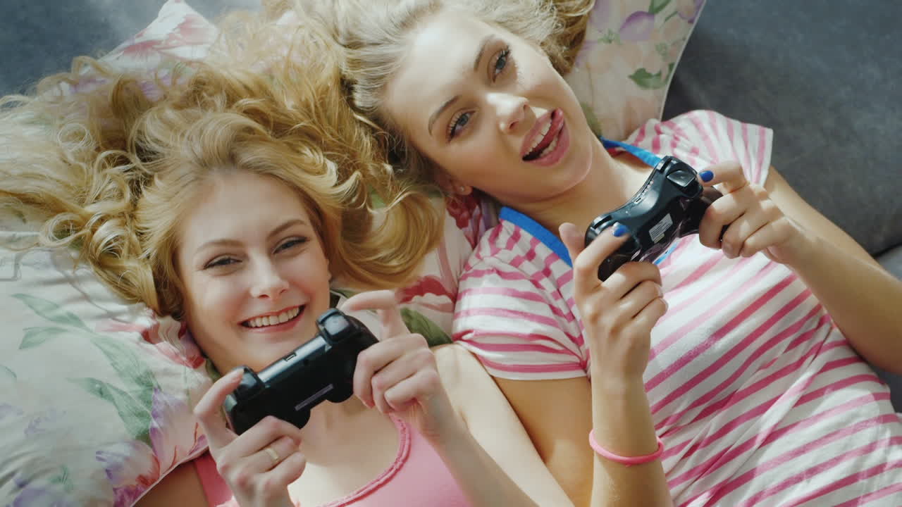 컴퓨터 콘솔 2에서 노는 두 젊은 여자 친구